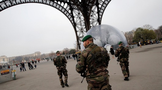 French soldiers patrols at the Eiffel Tower after a shooting at a French satirical newspaper, in Paris, France, Wednesday, Jan. 7, 2015. France reinforced security at houses of worship, stores, media offices and transportation after masked gunmen stormed the offices of a French satirical newspaper Wednesday, killing at least 11 people before escaping, police and a witness said. The weekly has previously drawn condemnation from Muslims. (AP Photo/Christophe Ena)