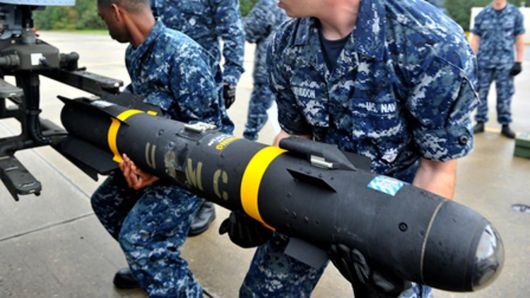 USMC Hellfire missile being loaded by US Navy sailors on an aircraft mount. Note the size of the missile requires two men to hold it up.